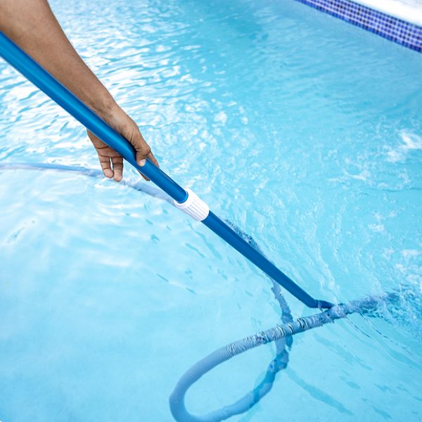 Pool maintenance and cleaning with vacuum hose. People cleaning swimming pool with suction hose. Close-up of man cleaning a swimming pool with a vacuum hose